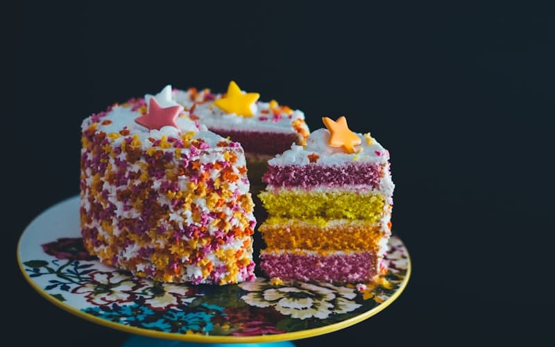 Colorful birthday cake with one slice served